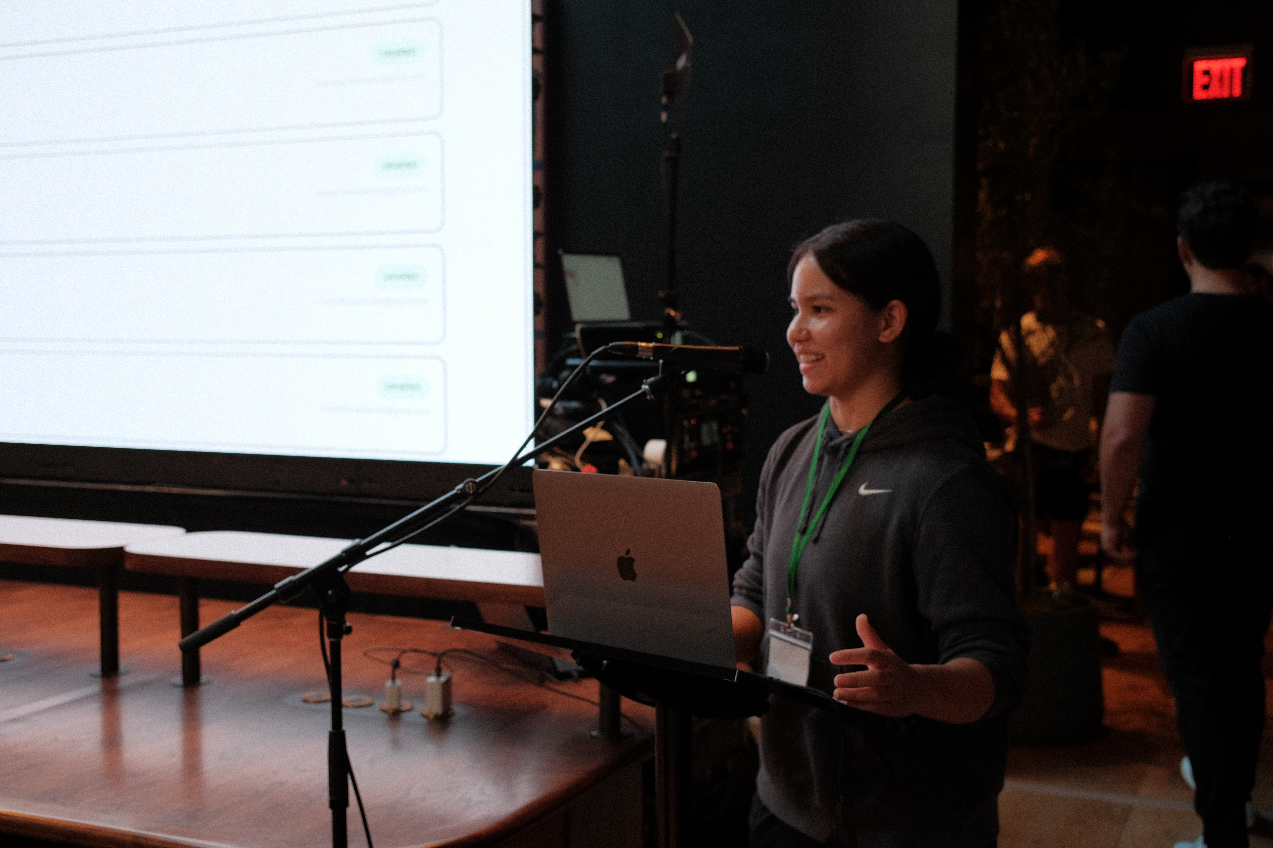 A NextNode Studio team member presenting from a laptop at a podium on stage